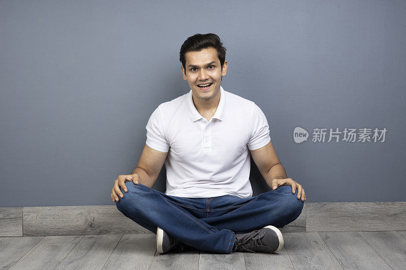 男人盘腿坐在地板上的stock photo